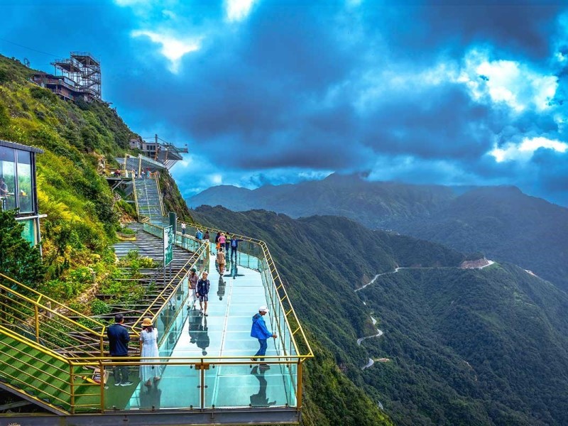 Tourists walking on Sa Pa glass bridge with panoramic views of the highlands