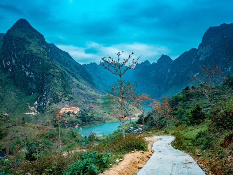 A panoramic view of Ha Giang Loop in Vietnam, featuring winding roads, green hills, and dramatic scenery.