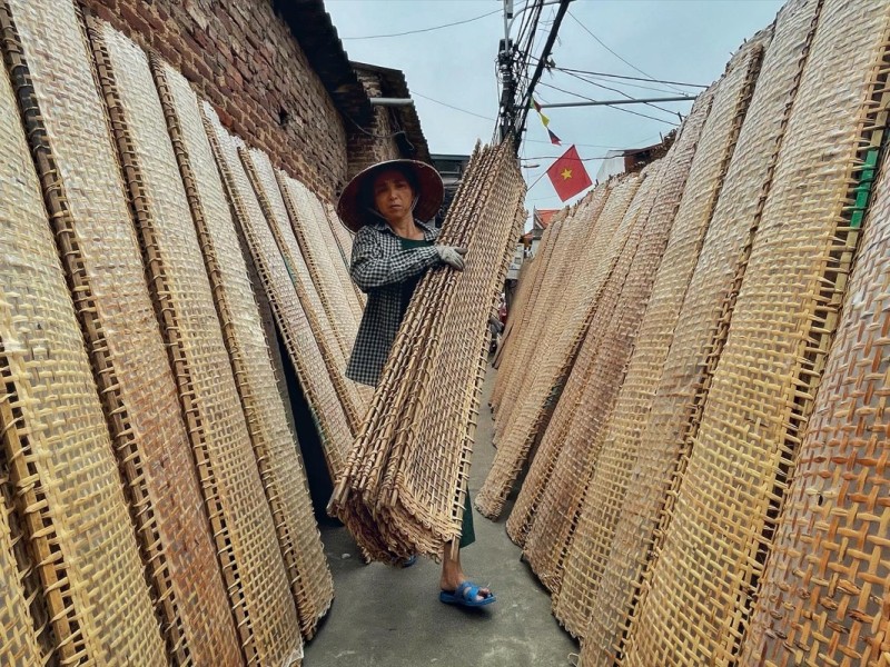 Woman drying rice papers in Tho Ha village, Bac Giang, traditional craft scene