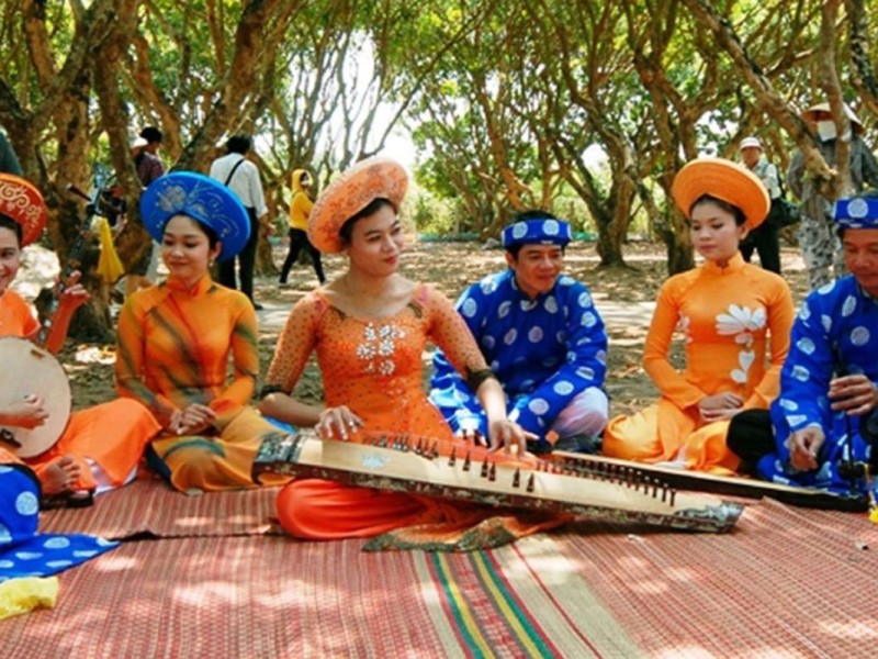 Traditional musical performance at Cai Mon Fruit Garden Village, with performers in traditional costumes in Ben Tre.