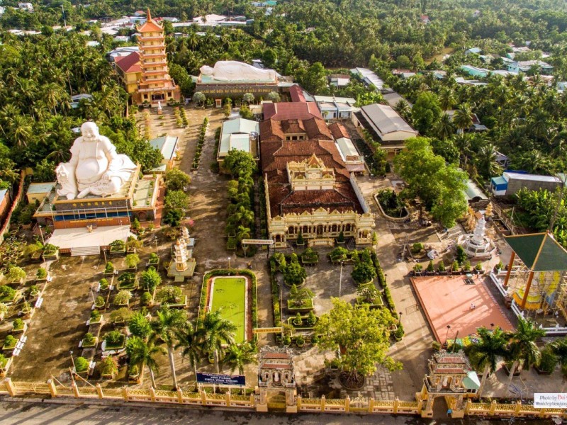 Aerial view of Vinh Trang Pagoda, a stunning Buddhist temple in Tien Giang, surrounded by lush greenery.