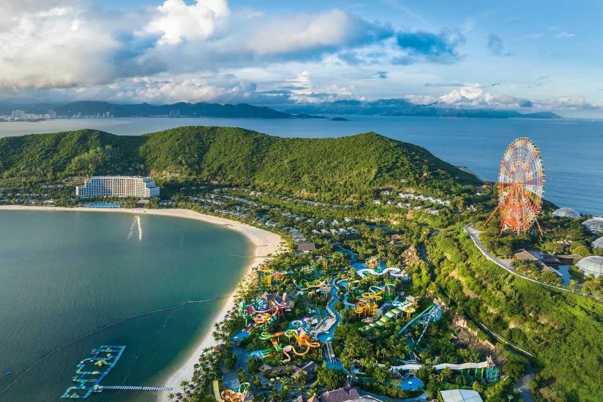 VinWonders Amusement Park Nha Trang Aerial view of VinWonders with a beach, theme park rides, and a giant Ferris wheel.