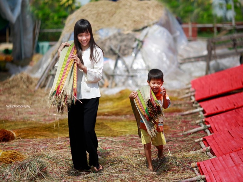 Close-up of hands weaving mats in Dinh Yen Village, highlighting the skilled craftsmanship in Dong Thap.