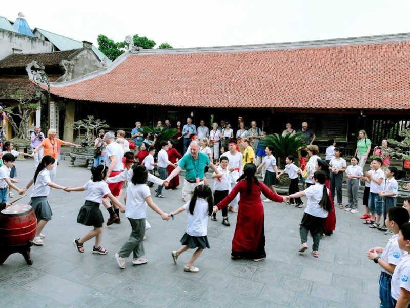 Students and tourists joining hands during a Xoan singing ceremony at the Hung Kings Temple in Phu Tho