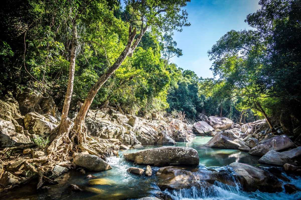 Central cascade of Ba Ho waterfall plunging into a green rock pool on the Nha Trang trekking tour.