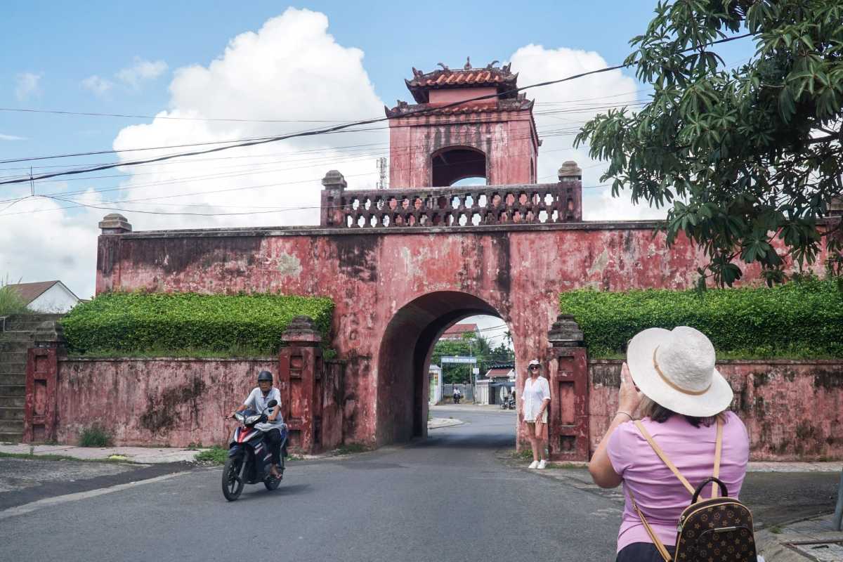 View of Dien Khanh Citadel outer wall and entrance surrounded by greenery under blue sky