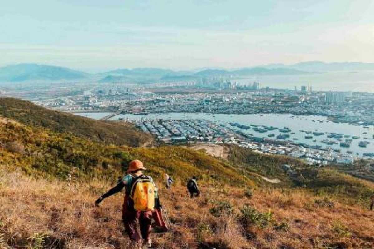 Hiker walking on Kong Forest trail with panoramic city views in the background