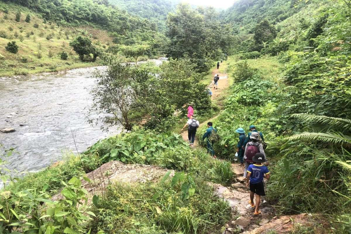 Adventurer crossing suspension bridge on Kong Forest hiking trail during trekking tour