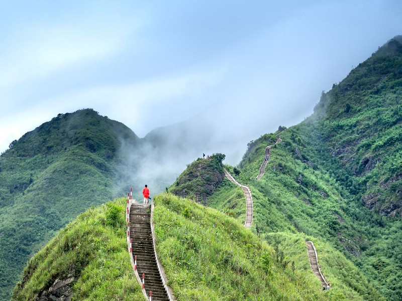 Một người trekking trên đỉnh núi Bình Liêu với mây mù bao phủ