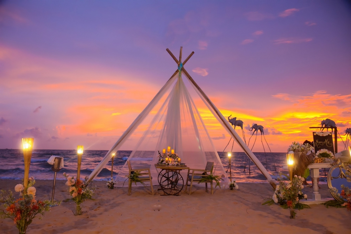 Candle-lit beach tent with romantic sunset ambiance and elephant statues at Sunset Sanato