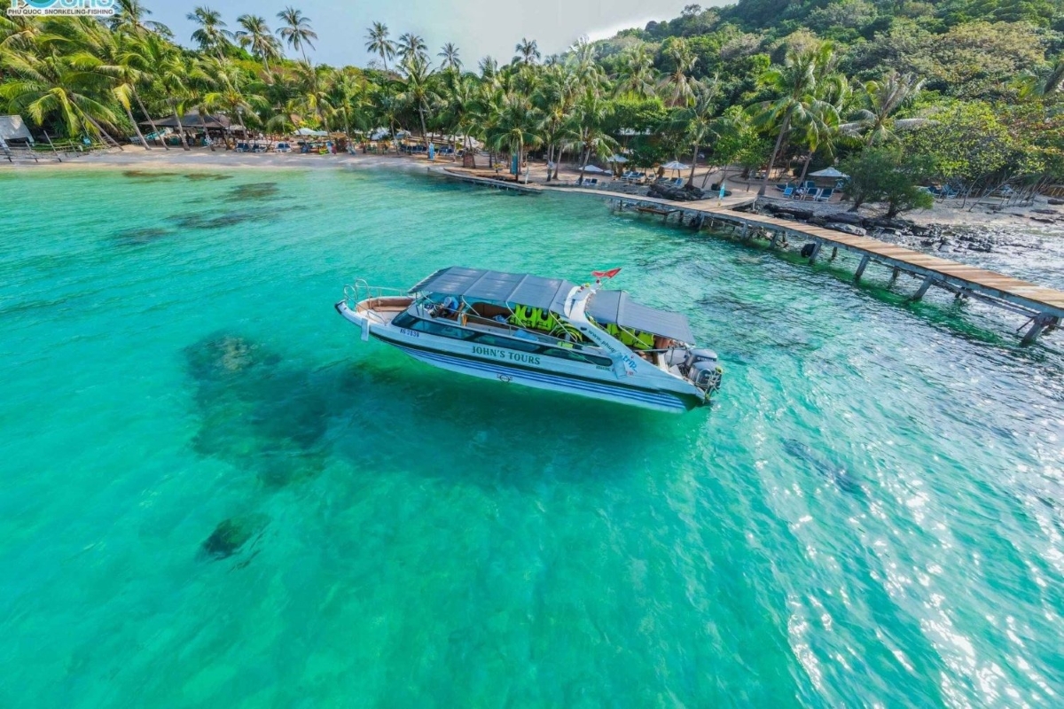 A speedboat floating over crystal-clear waters approaching the dock at May Rut Island