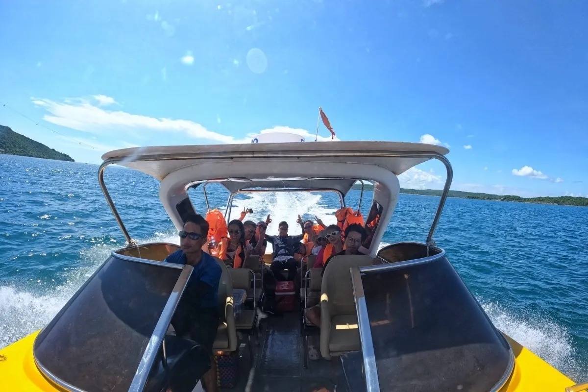 Group of tourists enjoying a high-speed boat ride across Phu Quocâ€™s turquoise waters