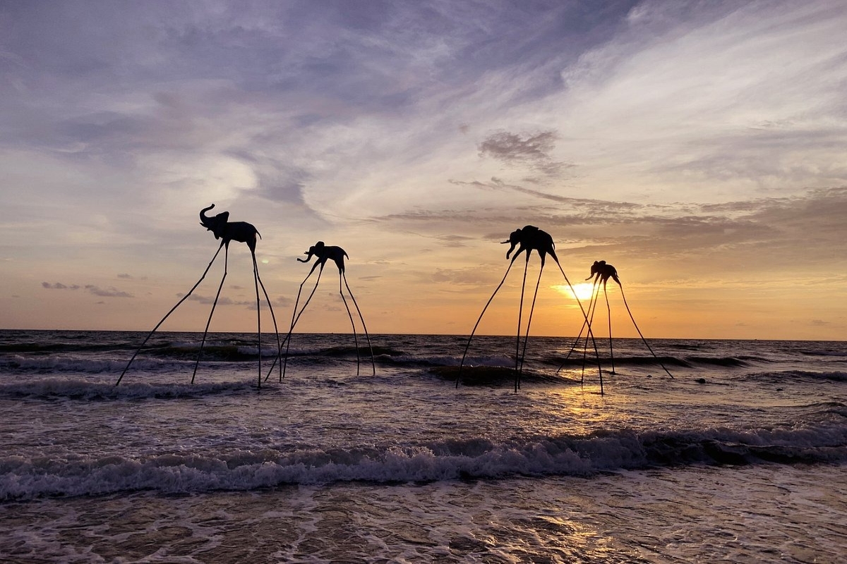 Silhouettes of elephant statues on tall stilts during sunset at Sunset Sanato in Phu Quoc