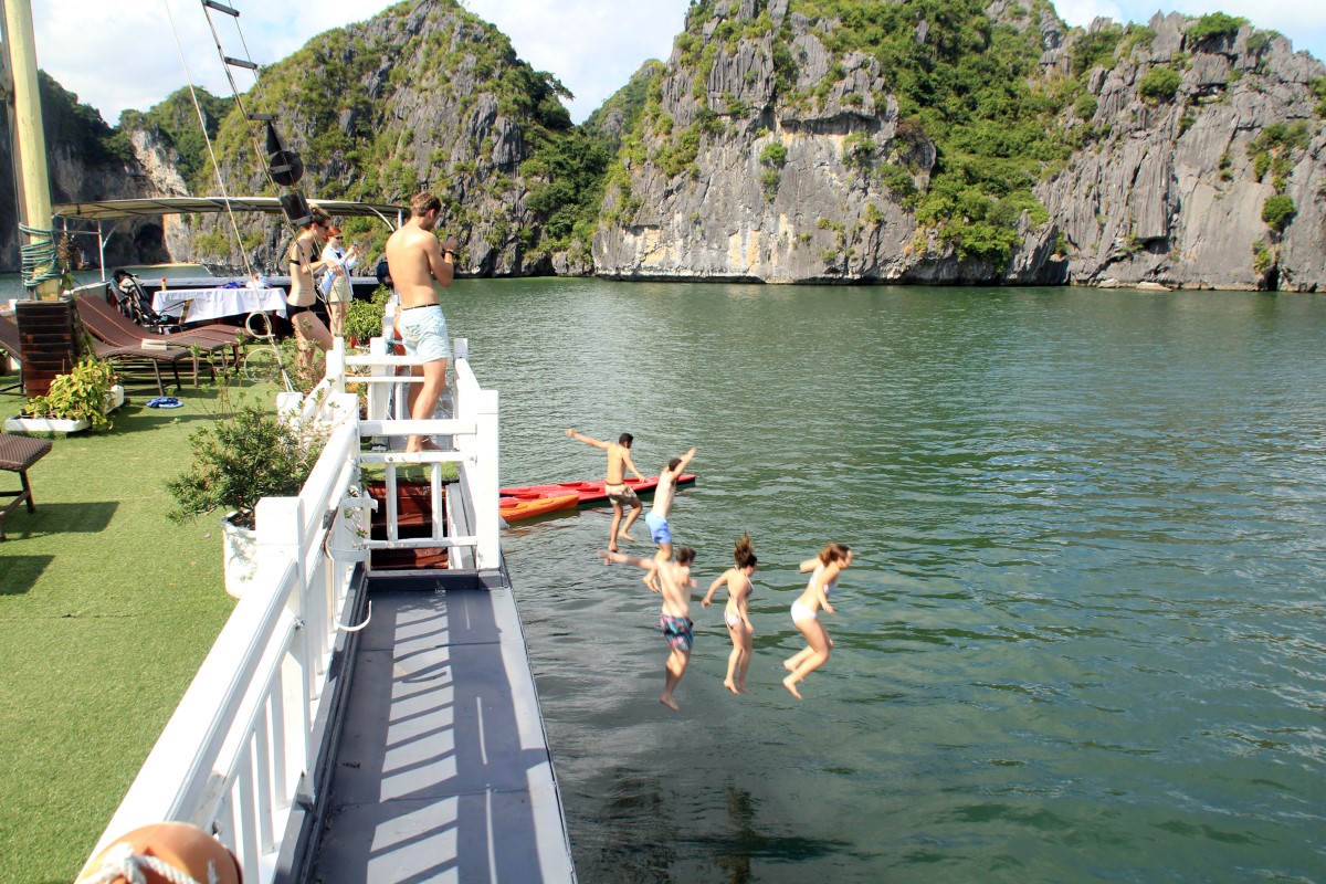 People enjoying outdoor activities on a boat in Bai Tu Long Bay, Vietnam