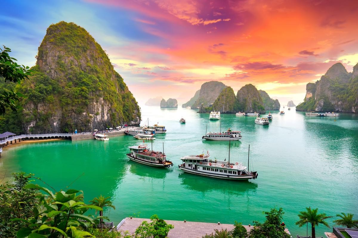 Sunset over Ha Long Bay with boats and limestone islands